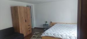 a bedroom with a bed and a wooden cabinet at Casa de vacanță Mira in Cîmpu lui Neag