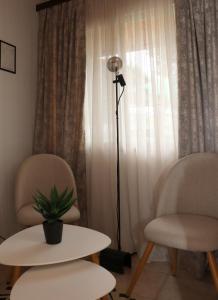 a room with two chairs and a table and a lamp at Charming Villa by the Sea in Nea Kalikratia