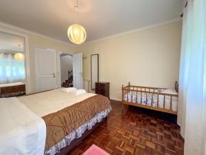 een slaapkamer met 2 bedden en een wieg bij Spacious Villa in Vila Nova de Gaia in Vila Nova de Gaia