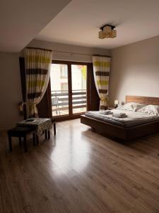 a bedroom with a large bed and a large window at Szklarnia Restauracja i Pokoje Gościnne in Swornegacie 