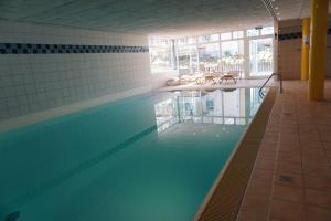 een zwembad met stoelen in een gebouw bij Ostseepark Waterfront-Karavelle in Heringsdorf