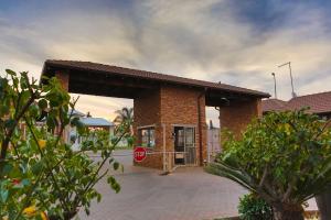 un edificio de ladrillo con una señal de stop delante de él en Rudman Townhouses - OR Tambo Airport, en Boksburg