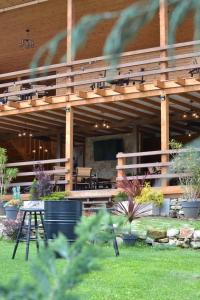 a wooden building with a table and chairs in a yard at Tinutul Luanei Glamping Resort in Bozioru