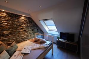 a bedroom with a bed and a stone wall at Ommelsbacher Mühle in Isenburg