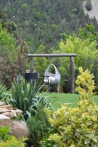 a garden with a swing and a chair in the grass at Tinutul Luanei Glamping Resort in Bozioru +53 photos