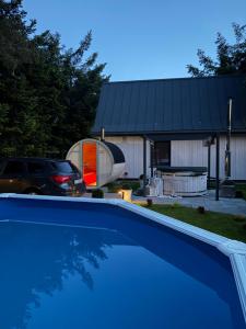 a swimming pool in front of a house with a garage at Domek Marzenie in Radawa