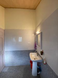 a bathroom with a white sink and a mirror at Reconnect By GoingZero in Manāli