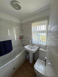 a white bathroom with a sink and a toilet at 449 Driftwood in Scratby +17 photos