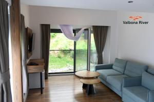 a living room with a couch and a table and a window at Valbona River Hotel in Jah Salih