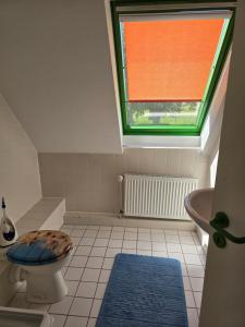 a bathroom with a toilet and a window at Ferienwohnung Kloster Tempzin 19412 in Tempzin +24 photos