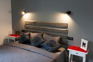 a bedroom with a bed with blue pillows and two tables at Pļavas in Ainaži