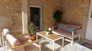 a patio with two chairs and a table at Casa mirador Tía Amalia in San Mamede de Carnota