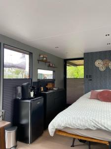 una camera con letto e cucina di Hotelkamer op water Houseboat Wetterhûske Friesland a Suameer