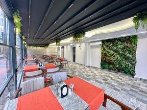 a restaurant with red tables and chairs and plants at Bloomtalya Hotel in Antalya