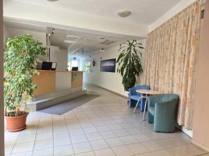 poczekalnia w szpitalu ze stołem i krzesłami w obiekcie Manna Wellness Apartman Zalakaros w Zalakaros +28 zdjęć