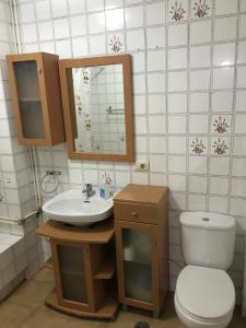 a bathroom with a sink and a toilet and a mirror at A de Olga in Porriño