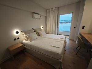 a bedroom with a large bed with a view of the ocean at 9 Muses Apartments in Agios Nikolaos