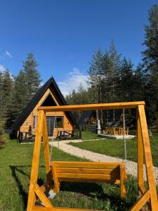 een houten bank voor een blokhut bij Pine forest-Black in Žabljak