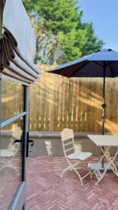 a patio with an umbrella and a table and chairs at The Stables Kildare - adults only in Kildare +32 photos