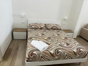 a bed with a brown and white blanket on it at Da MARTINA in Porto Cesareo