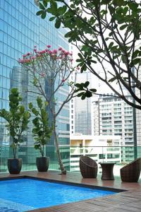 een zwembad in een gebouw met bomen en gebouwen bij Verdant Hill Hotel Kuala Lumpur in Kuala Lumpur