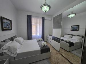 a bedroom with two beds and a mirror at Sea view Captain Apartment Durres in Durrës