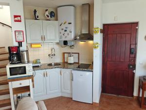 a kitchen with white cabinets and a red door at CastelloHouse, The Best Sea View, in front of Carvoeiro beach in Carvoeiro