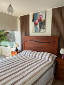 a bedroom with a bed and a window at Departamento Papudo Playa Piscina in Papudo