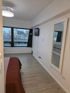 a room with a bed and a large window at Infinit Point Apartment in Buenos Aires