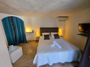 a bedroom with a large white bed with two pillows at Villa Petra Bianca Suites & Chambres in Bonifacio