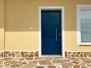 a blue door on the side of a house at Casa Arsida in Anavissos