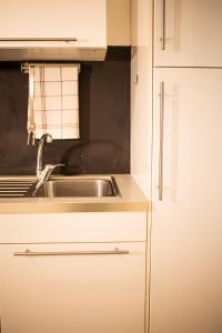 een keuken met een wastafel en een witte kast bij Appartamento Panoramic in Lerici