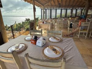 a table with plates of food on it with the ocean at Pousada Vila Canoa in Canoa Quebrada