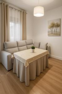 a living room with a table and a couch at Alojamiento Baeza - El Limonero A in Baeza