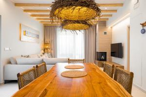 a living room with a wooden table and a couch at Sirin Luxury Suites Groundfloor in Haraki