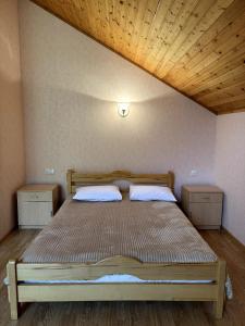 a bed in a bedroom with a wooden ceiling at Alpina Guest House in Yeghegis