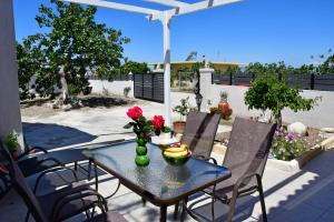 a table with a vase of flowers on a patio at Da Vinci kavouropetra in Aegina Town