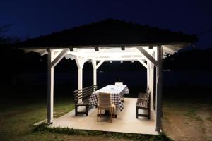 a white gazebo with a table and chairs at Kuća za odmor Eagle's nest in Brnjica