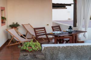 a patio with a wooden table and chairs at Dammuso Surya Cloe in Pantelleria