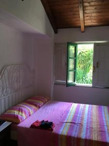 a bedroom with a bed and a window with a bag on it at La casa di Filippo e Filippa in Gioiosa Marea