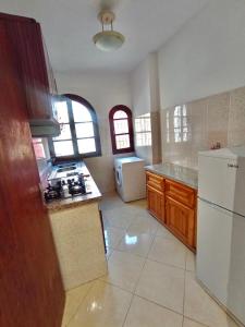 eine Küche mit Herd und weißem Kühlschrank in der Unterkunft خليل in Oulad Akkou
