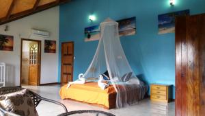 a bedroom with a bed with a mosquito net at Belle Amie Self Catering in La Digue