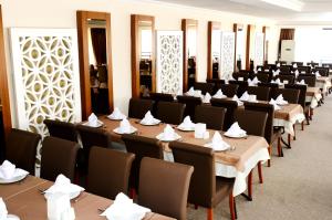 una stanza piena di tavoli e sedie con tovaglioli sopra di Hotel By Karaaslan Inn a Kusadası