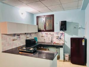 a kitchen with a counter top and a refrigerator at Acacia Apartment 707 in Lucknow
