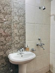 a bathroom with a white sink and a shower at Acacia Apartment 707 in Lucknow +44 photos