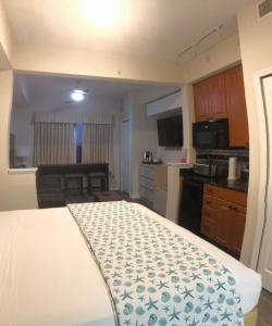 Una pequeña cocina con una cama en una habitación. en Universal-Disney Dream Studio Ap - The Point, en Orlando