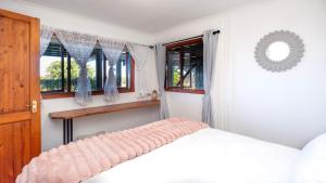 a white bedroom with a bed and windows at Sea Breeze Apartment in Wilderness +52 photos