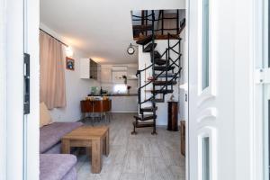 a spiral staircase in a living room with a kitchen at Apartman Donadina-Dalmatian heritage house in Trogir