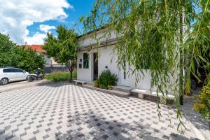 a white house with a tree in front of it at Apartman Donadina-Dalmatian heritage house in Trogir
