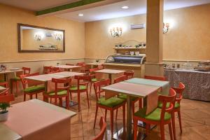 a restaurant with tables and chairs and a counter at Hotel Matteotti in Vercelli